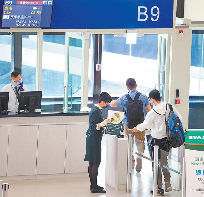 日本政府日前宣布，接種過BNT、莫德納或是AZ疫苗的旅客，入境後居家檢疫可減免4天，但不包括國產高端疫苗。圖為桃園機場出境管制區內，2名前往東京的旅客正在登機。（范揚光攝）