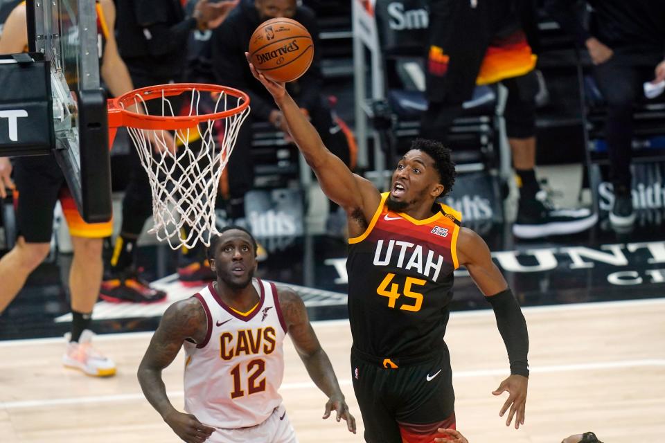 Utah Jazz guard Donovan Mitchell (45) goes to the basket as Cleveland Cavaliers forward Taurean Prince (12) looks on in the first half during an NBA basketball game Monday, March 29, 2021, in Salt Lake City. (AP Photo/Rick Bowmer)