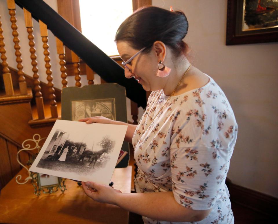 Amy Pence shows a picture of former owners of the Moore-Lindsay Historical House Museum in Norman.