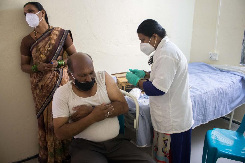 Jaidee Meshram, an auxiliary nurse midwife, vaccinates a man against COVID-19 in Tardal village in Maharashtra, India.