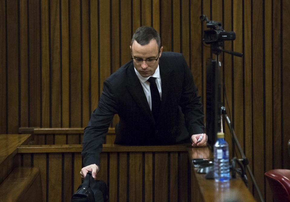 Oscar Pistorius puts his bag upon his arrival at a courtroom for his ongoing murder trial at the high court in Pretoria, South Africa, Tuesday, May 13, 2014. Pistorius is charged with the shooting death of his girlfriend Reeva Steenkamp on Valentine's Day in 2013. (AP Photo/Daniel Born, Pool)