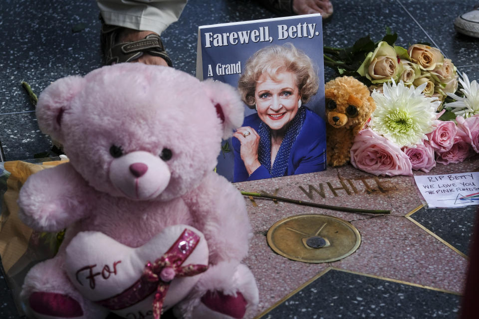 Flowers, stuff toys and cards are displayed at the Hollywood Walk of Fame star of the late actress Betty White, Friday, Dec. 31, 2021, in Los Angeles. White, whose saucy, up-for-anything charm made her a television mainstay for more than 60 years, whether as a man-crazy TV hostess on “The Mary Tyler Moore Show” or the loopy housemate on “The Golden Girls,” has died. She was 99. (AP Photo/Ringo H.W. Chiu)