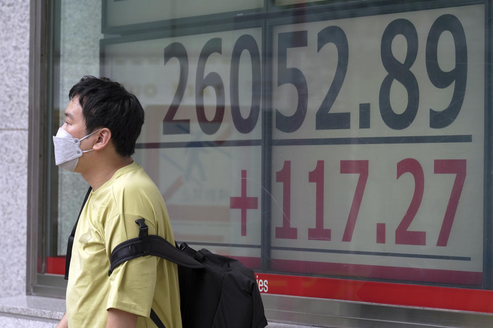 A person wearing a protective mask stands in front of an electronic stock board showing Japan's Nikkei 225 index at a securities firm Monday, July 4, 2022, in Tokyo. Shares were mixed in Asia on Monday while U.S. futures fell ahead of the July 4 holiday in the U.S. (AP Photo/Eugene Hoshiko)