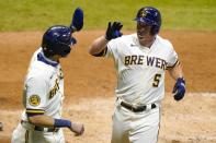 Milwaukee Brewers' Jedd Gyorko is congratulated by Christian Yelich after hitting a two-run home run during the eighth inning of a baseball game against the Minnesota Twins Tuesday, Aug. 11, 2020, in Milwaukee. (AP Photo/Morry Gash)