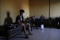 Youths rest on beds a sports facility being used as a government-run shelter where citizens returning home are required by law to quarantine for two weeks and pass two consecutive COVID-19 tests, as a preventive measure amid the COVID-19 pandemic in Hermandarias, Paraguay, near the border with Brazil, Thursday, June 24, 2020. With only 7 million people, a stagnant economy, high poverty, and a weak public health system, Paraguay moved to slow coronavirus in March by closing borders and imposing the quarantine restrictions, along with closing schools and public events and declaring a nighttime curfew. (AP Photo/Jorge Saenz)