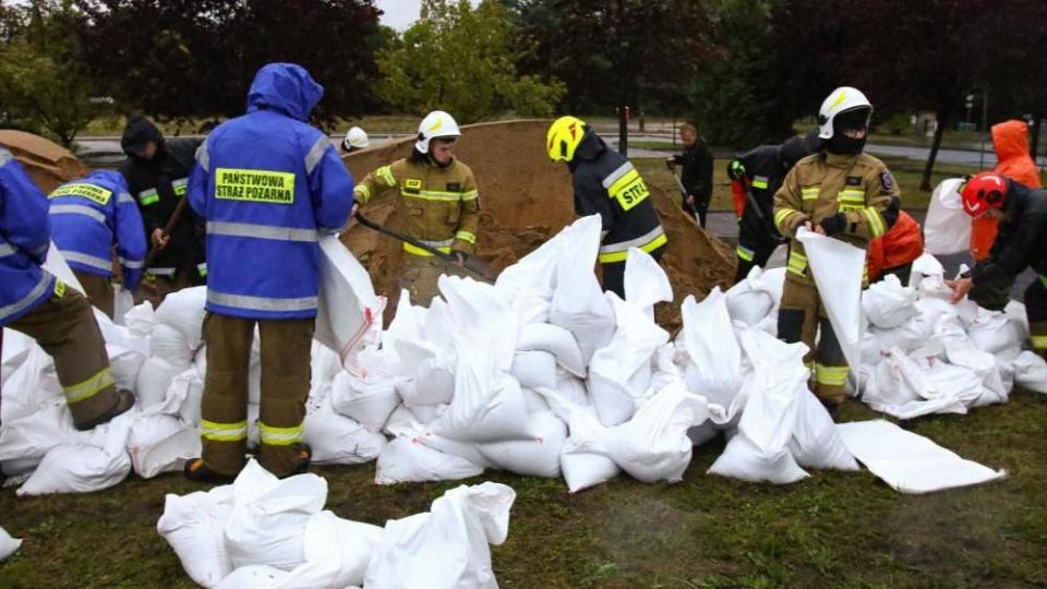 Firefighters build barriers with sandbags against floodwaters, near the Biala Glucholaska River, in Glucholazy, southwestern Poland, September 14, 2024. 