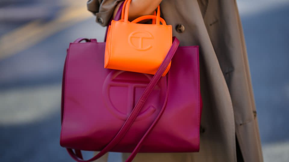 Samia Laaboudi wears a beige trench coat, a neon orange handbag from Telfar and a burgundy handbag from Telfar, during New York Fashion Week, on September 14, 2022 in New York City. - Edward Berthelot/Getty Images