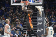 Orlando Magic center Mo Bamba (5) dunks the ball between Charlotte Hornets center Mason Plumlee, left, and forward Miles Bridges (0) during the first half of an NBA basketball game, Wednesday, Nov. 24, 2021, in Orlando, Fla. (AP Photo/Phelan M. Ebenhack)