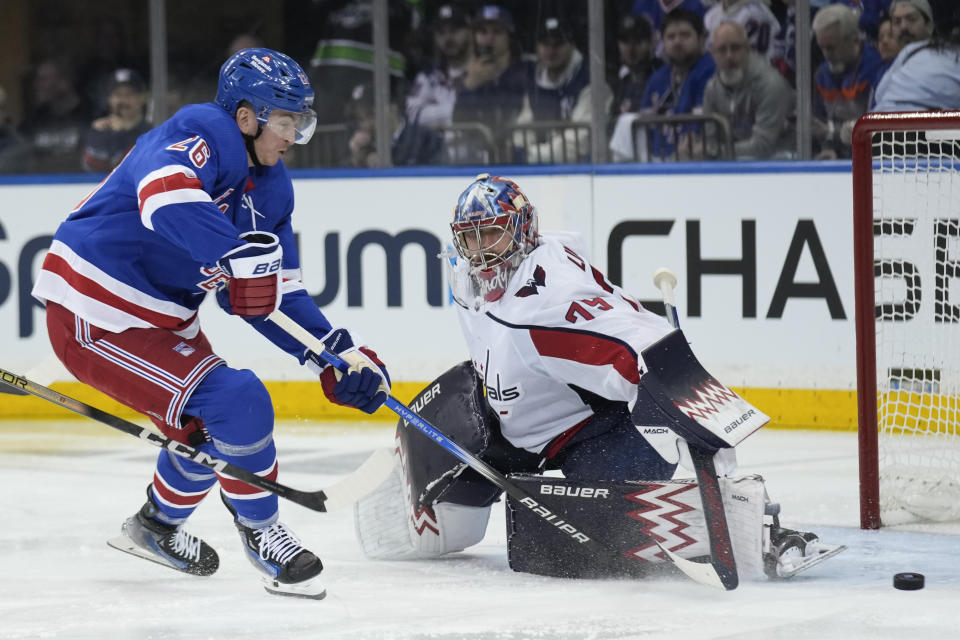 New York Rangers' Jimmy Vesey, left, takes a shot on Washington Capitals goaltender Charlie Lindgren during the third period in Game 1 of an NHL hockey Stanley Cup first-round playoff series, Sunday, April 21, 2024, in New York. (AP Photo/Seth Wenig)