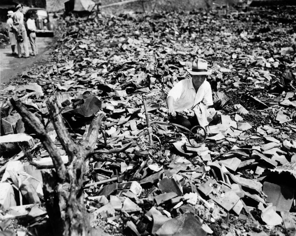 FILE - In this Sept. 17, 1945, file photo, a Japanese civilian salvages a piece of what was once a child's tricycle in Nagasaki, Japan. The city marks the 75th anniversary of the U.S. atomic bombing of Aug. 9, 1945. It was a second nuclear bomb dropped by the U.S. three days after it made the world’s first atomic attack on Hiroshima. Japan surrendered on Aug. 15, ending World War II and its nearly a half-century aggression toward Asian neighbors. Dwindling survivors, whose average age exceeds 83, increasingly worry about passing their lessons on to younger generations. (AP Photo/Stanley Troutman, Pool, File)