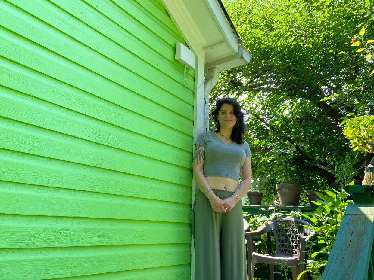 Elizabeth Szabo stands outside her home in Staunton next to the IQAir station monitor she purchased on Friday, July 14, 2023.