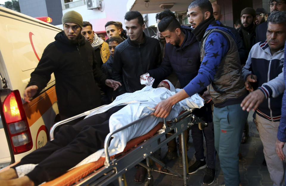 Relatives wheel a wounded youth, who was shot by Israeli troops in the head during a protest at the Gaza Strip's border with Israel, into the treatment room of Shifa hospital in Gaza City, Friday, Jan. 11, 2019. (AP Photo/Adel Hana)