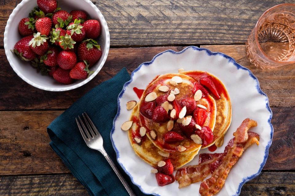 Breakfast for dinner doesn't have to be a last resort. In fact, I think of it as a highlight of the week. Caramelized strawberries and crunchy almonds dress up buttermilk pancakes with plenty of flair, but if strawberries aren't in season, you can substitute whatever fruit you have on hand. <a href="https://www.epicurious.com/recipes/food/views/buttermilk-pancakes-with-roasted-strawberries-56389558?mbid=synd_yahoo_rss" rel="nofollow noopener" target="_blank" data-ylk="slk:See recipe." class="link rapid-noclick-resp">See recipe.</a>