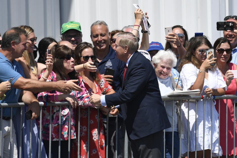 Sen. Lindsey Graham, R-S.C., greets people at Francis S. Gabreski Airport in Westhampton Beach, N.Y., Friday, Aug. 9, 2019, after arriving via Air Force One with President Donald Trump. Trump is in the Hamptons to attend a pair of fundraisers before heading to his golf club in New Jersey for vacation. (AP Photo/Susan Walsh)