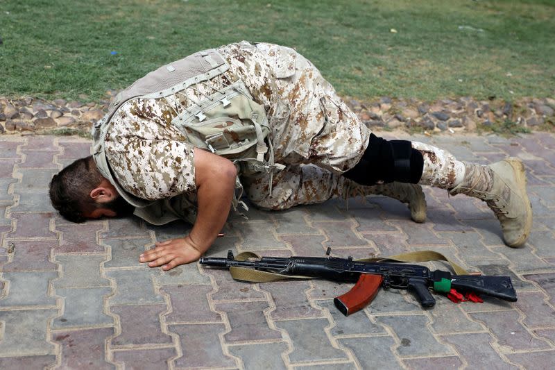 A fighter loyal to Libya's internationally recognised government prays after regaining control over Tarhouna city