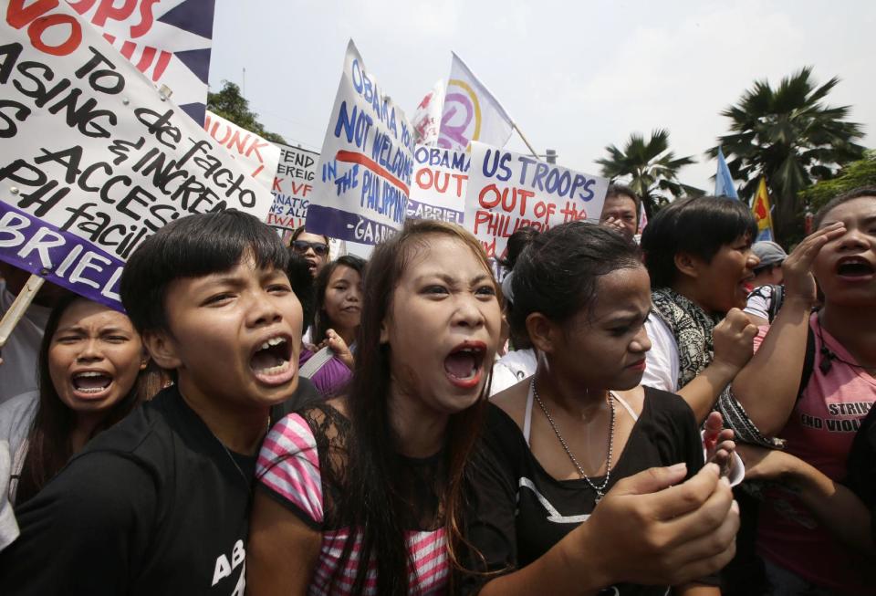 Protesters shout slogans during a rally at the U.S. Embassy against next week's visit by U.S. President Barack Obama Wednesday, April 23, 2014, in Manila, Philippines. Philippine police armed with truncheons, shields and water hoses clashed with more than 100 left-wing activists who rallied at the embassy to oppose a visit by Obama and a looming pact that will increase the American military presence in the Philippines. (AP Photo/Bullit Marquez)