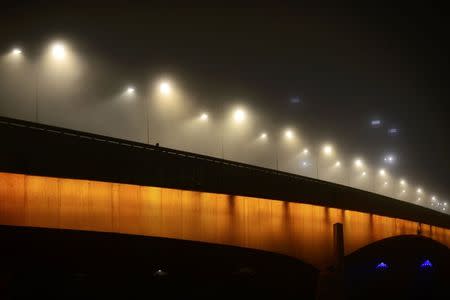 Fog shrouds London Bridge as a man takes a late evening stroll in London, Britain November 1, 2015. REUTERS/Dylan Martinez