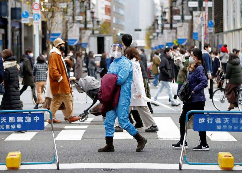 Imagen de archivo de una mujer que viste equipo de protección personal (PPE) mientras camina por la calle en medio de la pandemia de COVID-19, en el distrito comercial de Ginza, en Tokio