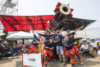 Team members from "Firefighting Life" poses with their man made flying machine in Taichung, a port city in central Taiwan on Sunday, Sept. 18, 2022. Pilots with homemade gliders launched themselves into a harbor from a 20-foot-high ramp to see who could go the farthest before falling into the waters. It was mostly if not all for fun as thousands of spectators laughed and cheered on 45 teams competing in the Red Bull “Flugtag” event held for the first time. (AP Photo/Szuying Lin)