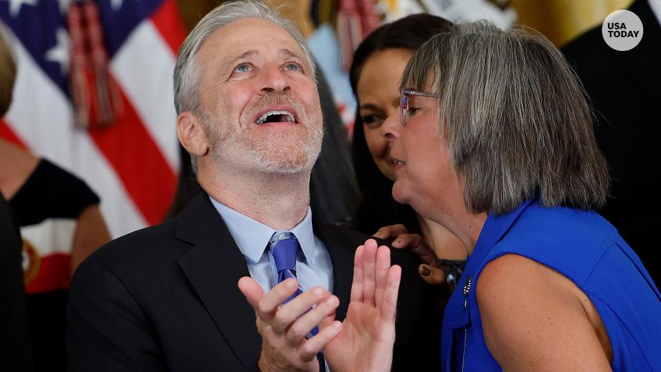 Comedian and activist Jon Stewart talks with Susan Zeier, mother-in-law of Sergeant First Class Heath Robinson, after U.S. President Joe Biden signs the PACT Act during a ceremony in the East room of the White House on August 10, 2022 in Washington, DC.