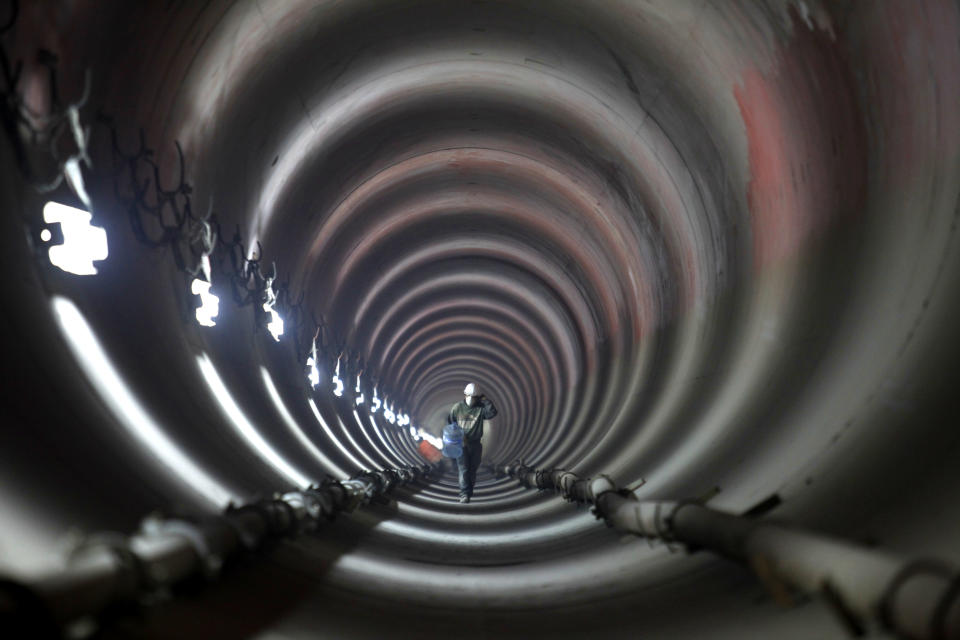 FILE - In this March 18, 2009 file photo, a worker walks inside an underground deep drainage tunnel system that handles rainwater and sewage in Mexico City. Experts agree the main source of the capital's odor problems is from an overwhelmed sewage system. (AP Photo/Dario Lopez-Mills, File)