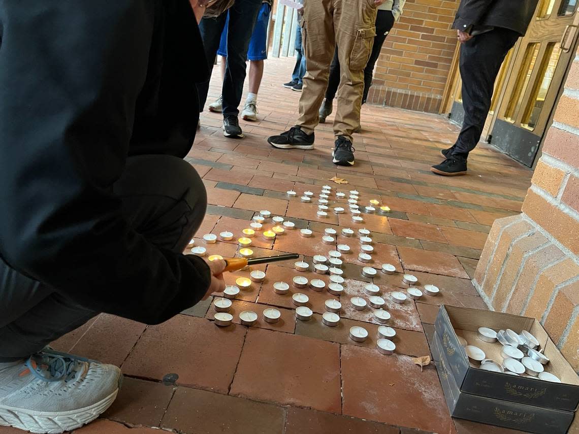 A participant in a prayer service for the victims of terror in Israel lights a candle in the shape of a star of David in Red Square at Western Washington University on Monday. The service was sponsored by the Chabad temple near campus.