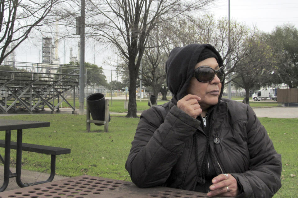 In this Thursday, Jan. 30, 2020, photo, Houston resident Guadalupe Ortiz sits at a city park located across the street from her home and a Valero oil refinery. Houston's lack of zoning has resulted in residents like Ortiz living next to petrochemical facilities and businesses that handle hazardous substances. (AP Photo/ Juan Lozano)