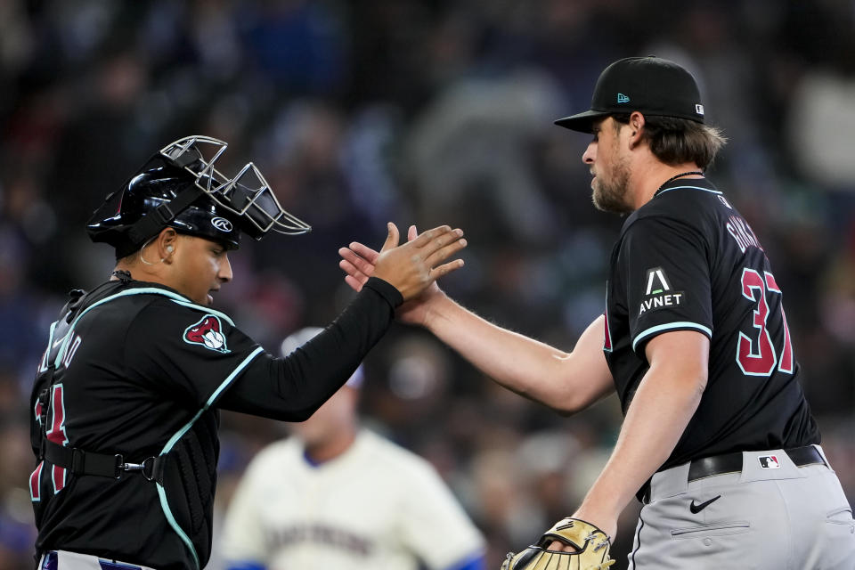 Arizona Diamondbacks catcher Gabriel Moreno greets relief pitcher Kevin Ginkel after Ginkel earned the save in a 3-2 win over the Seattle Mariners in a baseball game Sunday, April 28, 2024, in Seattle. (AP Photo/Lindsey Wasson)