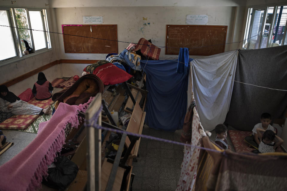 Palestinians take shelter at a school run by the U.N. after fleeing heavy Israeli missile strikes in the outskirts of Gaza City, Wednesday, May 19, 2021. The Gaza Strip's already feeble health system is being brought to its knees by the fourth war in just over a decade. At the school, no one wore a mask or could do any social distancing in the cramped quarters. (AP Photo/Khalil Hamra)