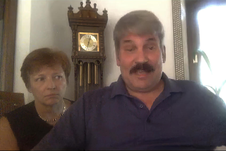 In this image from a video interview, John Manley, 58, a civilian U.S. Army public affairs officer at U.S. Africa Command in Stuttgart, Germany, and wife Heidi Mathis, 60, answer questions during an interview. Manley also spent 21 years in the Marines. Americans are grappling with an essential question as they try to get the information they need to stay safe during the coronavirus crisis: Whom do you trust? When Manley tested positive for COVID-19, his sister urged him to get on the malaria drug that she'd heard Fox News hosts plugging and that President Donald Trump was heralding as a potential “game changer” for fighting the coronavirus. But Manley was skeptical of using a drug not approved by the Food and Drug Administration for treating the virus and decided it was a gamble not worth taking. (AP Photo)