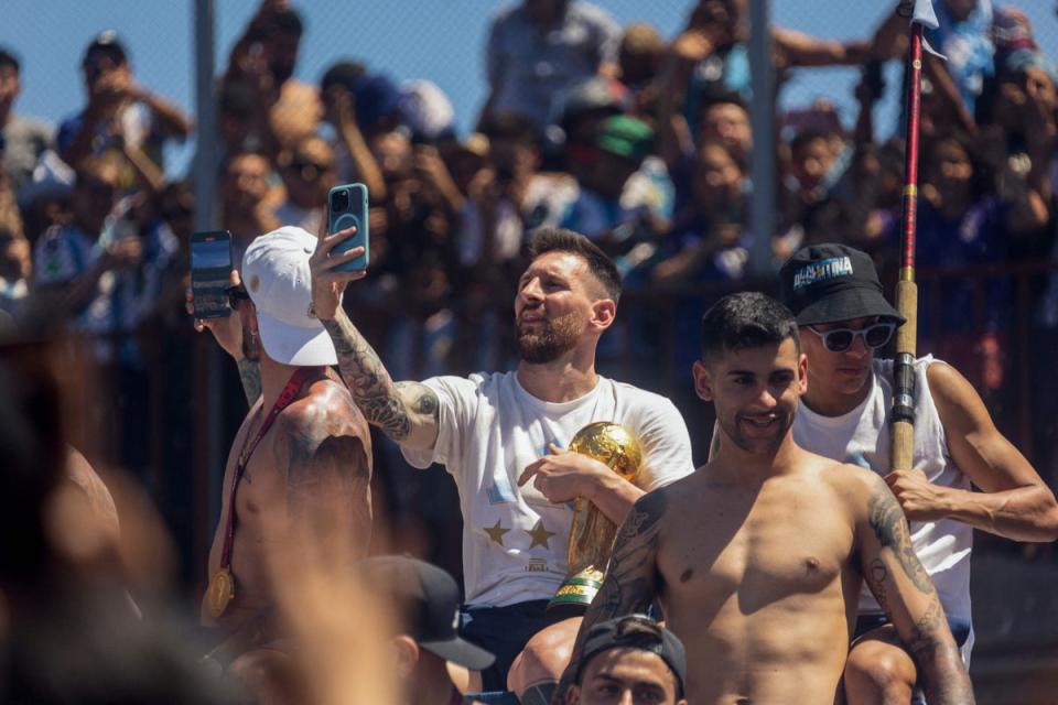 Lionel Messi takes pictures with his phone while celebrating on the bus (AFP/Getty)