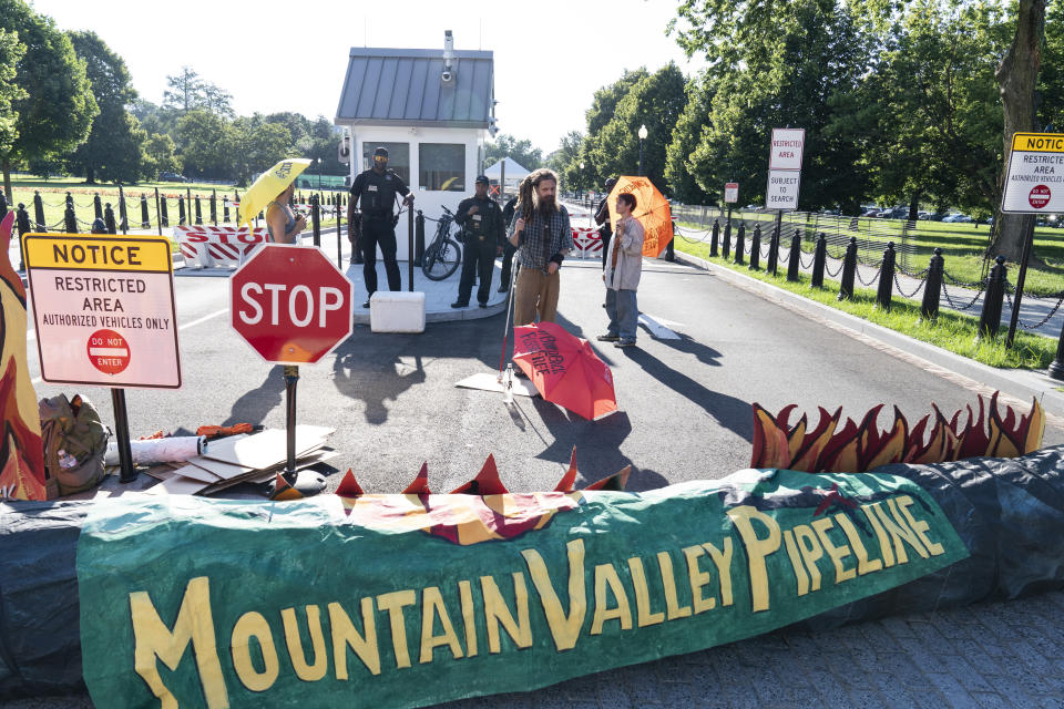 FILE - Activists with the indigenous environmental network block an entrance to the White House as they protest the line three pipeline, Wednesday, June 30, 2021, in Washington. The Supreme Court is allowing construction to resume on a contested natural-gas pipeline that is being built through Virginia and West Virginia. Work had been halted by the federal appeals court in Richmond, even after Congress ordered the project's approval as part of the bipartisan bill to increase the debt ceiling. President Joe Biden signed the bill into law in June. (AP Photo/Alex Brandon, File)