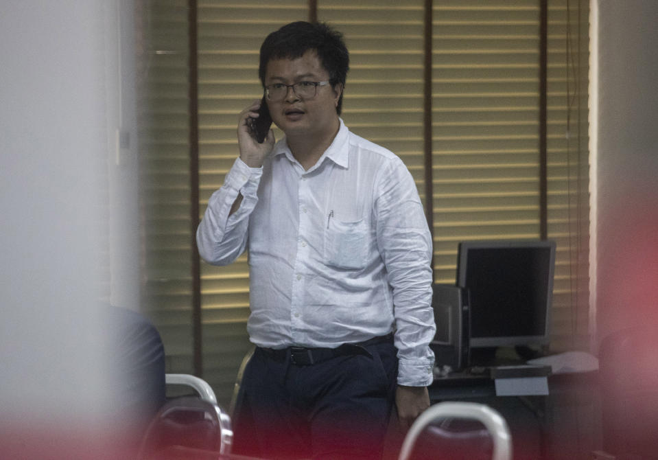 Pro-democracy activist and human rights lawyer Arnon Nampha talks on his phone at a police station, Friday, Aug, 7, 2020, in Bangkok, Thailand. The government cracked down on Friday with the arrests of some high profile members of the pro-democracy movement. Among them was Arnon, who was arrested on charges of sedition and defying an emergency decree the government instituted months ago to try to control the spread of the coronavirus. (AP Photo/Sakchai Lalit)