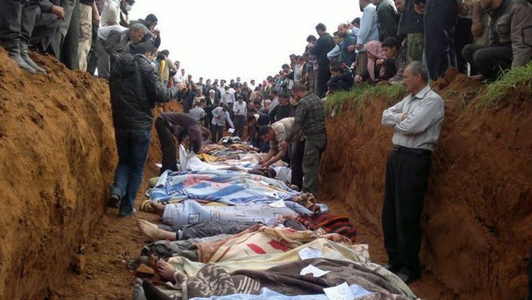 A picture released by the Local Coordination Committees in Syria (LCC) shows people standing around a mass grave in the town of Taftnaz, on April 5, 2012. UN investigators say they have "reasonable grounds" to believe both sides in Syria have used chemical weapons, and warned that crimes against humanity were now occurring daily in the war-torn country