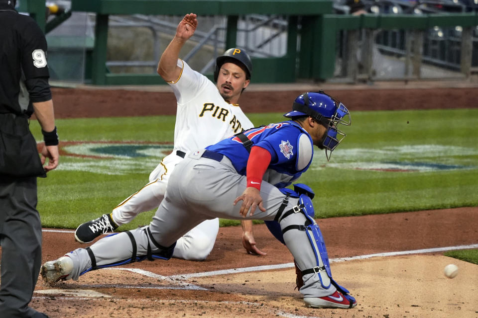 Pittsburgh Pirates' Bryan Reynolds slides as Chicago Cubs catcher Willson Contreras waits for the relay throw during the second inning of a baseball game in Pittsburgh, Saturday, April 10, 2021. Reynolds scored from second on a single by Colin Moran. (AP Photo/Gene J. Puskar)