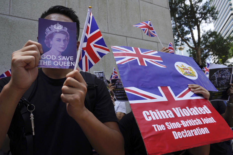 Protesters hold British flags and placards during a peaceful demonstration outside the British Consulate in Hong Kong, Sunday, Sept. 15, 2019. Hundreds of Hong Kong activists rallied outside the Consulate for a second time this month, bolstering calls for international support in their months-long protests for democratic reforms in the semi-autonomous Chinese territory. (AP Photo/Vincent Yu)