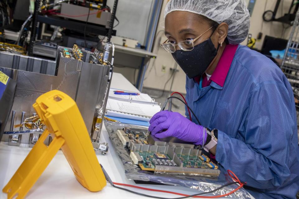 Engineer Yvette Tyler performs integration and testing on the electronics box for Europa Clipper's mass spectrometer.