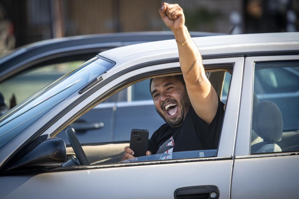 After guilty verdicts were announced, drivers go though the intersection of Florence Ave and Normandy Ave with fists raised