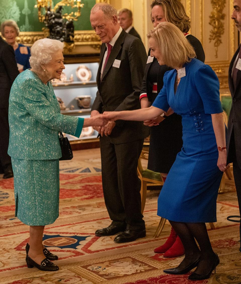 Britain's Queen Elizabeth II (L) greets UK Foreign Secretary Liz Truss (R) during a reception for international business and investment leaders at Windsor Castle