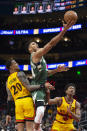 Milwaukee Bucks forward Giannis Antetokounmpo (34) scores over Atlanta Hawks forward John Collins (20) and De'Andre Hunter (12) during the first half of an NBA basketball game Monday, Jan. 17, 2022, in Atlanta. (AP Photo/Hakim Wright Sr.)