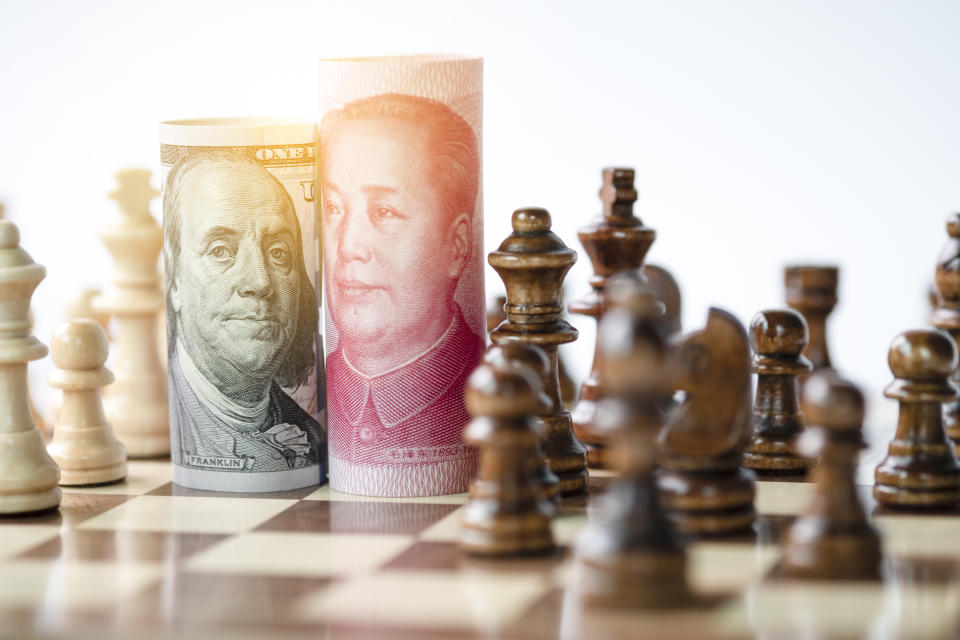 US dollar and Yuan banknote with chess for tariff trade war between United States and China which both countries battle by increase tax barrier of import and export product. Government and business.