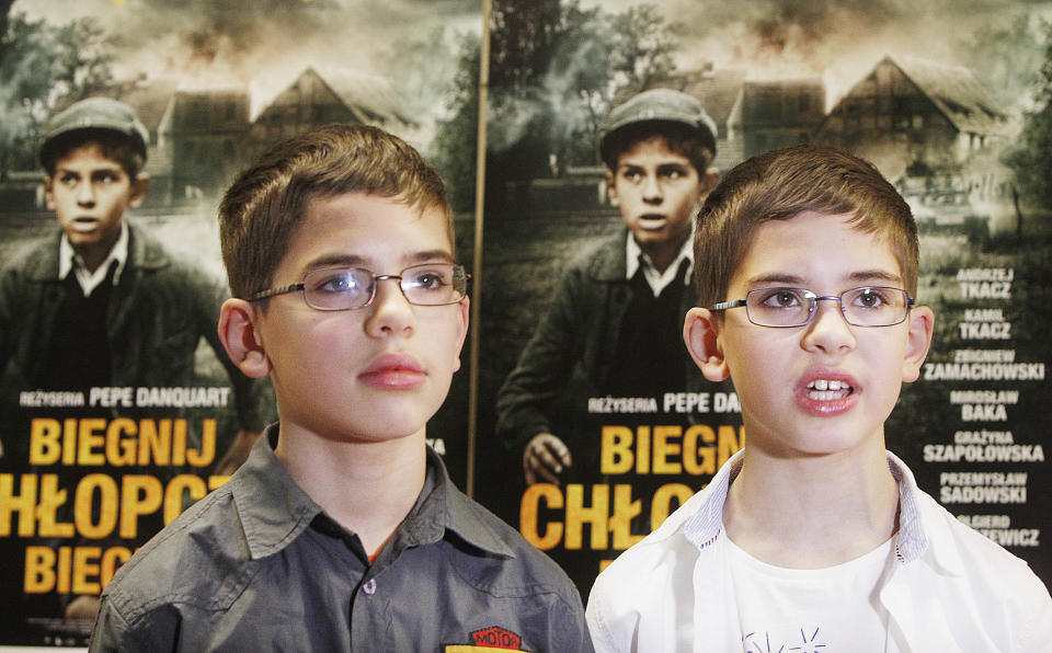 Actors, twin brothers Andrzej ,left,and Kamil Tkacz who play the role of young Yoram Friedman, a Jewish boy struggling to survive the Holocaust in the woods near Warsaw, with occasional help from local farmers but also facing their indifference, hatred and betrayal. The movie “Run, Boy, Run” by German director Pepe Danquart premiers at the Jewish History Museum in Warsaw, Poland, on Wednesday, Jan. 8, 2014. (AP Photo/Czarek Sokolowski)