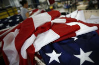 <p>American flags sit as a worker sews at the FlagSource facility in Batavia, Illinois, U.S., on Tuesday, June 27, 2017. (Photo: Jim Young/Bloomberg via Getty Images) </p>