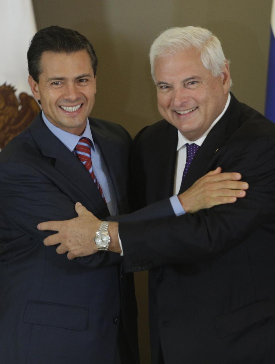 Mexico's President Enrique Pena Nieto, left, and Panama's President Ricardo Martinelli embrace after signing a Free Trade Agreement between both countries during the last day of the World Economic Forum on Latin America in Panama City, Thursday, April 3, 2014. (AP Photo/Arnulfo Franco)