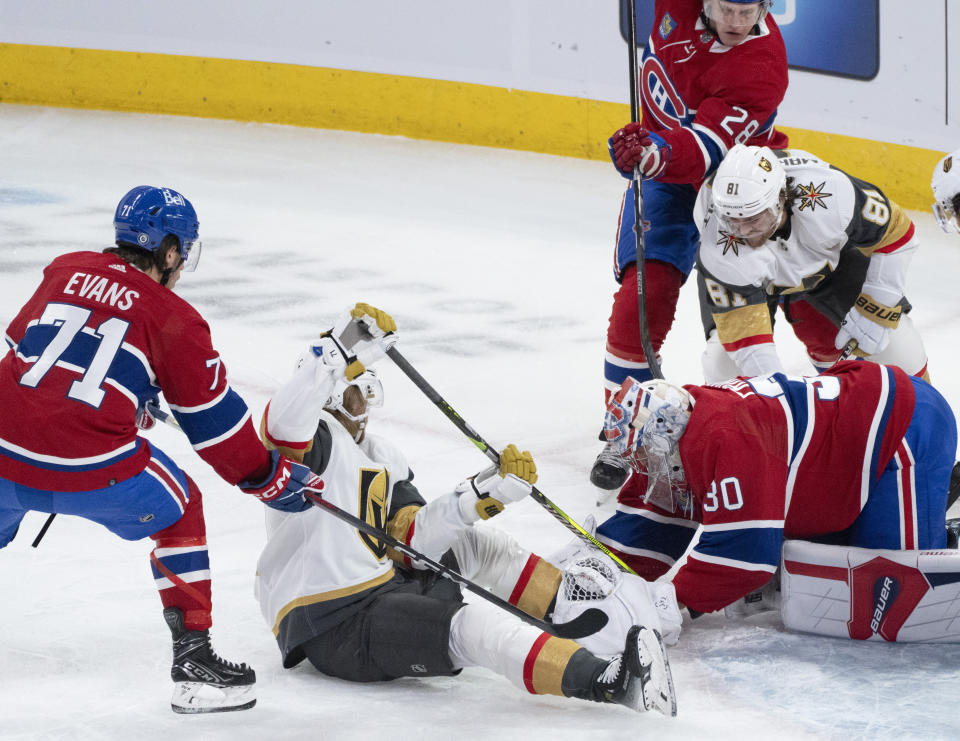 Montreal Canadiens goaltender Cayden Primeau (30) covers the puck as Vegas Golden Knights' William Karlsson (71) digs for the rebound during the first period of an NHL hockey game Thursday, Nov. 16, 2023, in Montreal. (Christinne Muschi/The Canadian Press via AP)