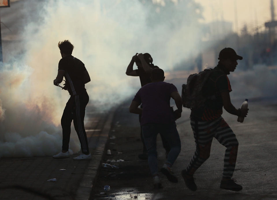 Iraqi security forces fire tear gas to disperse anti-government protesters during a demonstration in Baghdad, Iraq, Saturday, Oct. 5, 2019. The spontaneous protests which started Tuesday in Baghdad and southern cities were sparked by endemic corruption and lack of jobs. Security responded with a harsh crackdown, leaving more than 70 killed. (AP Photo/Hadi Mizban)