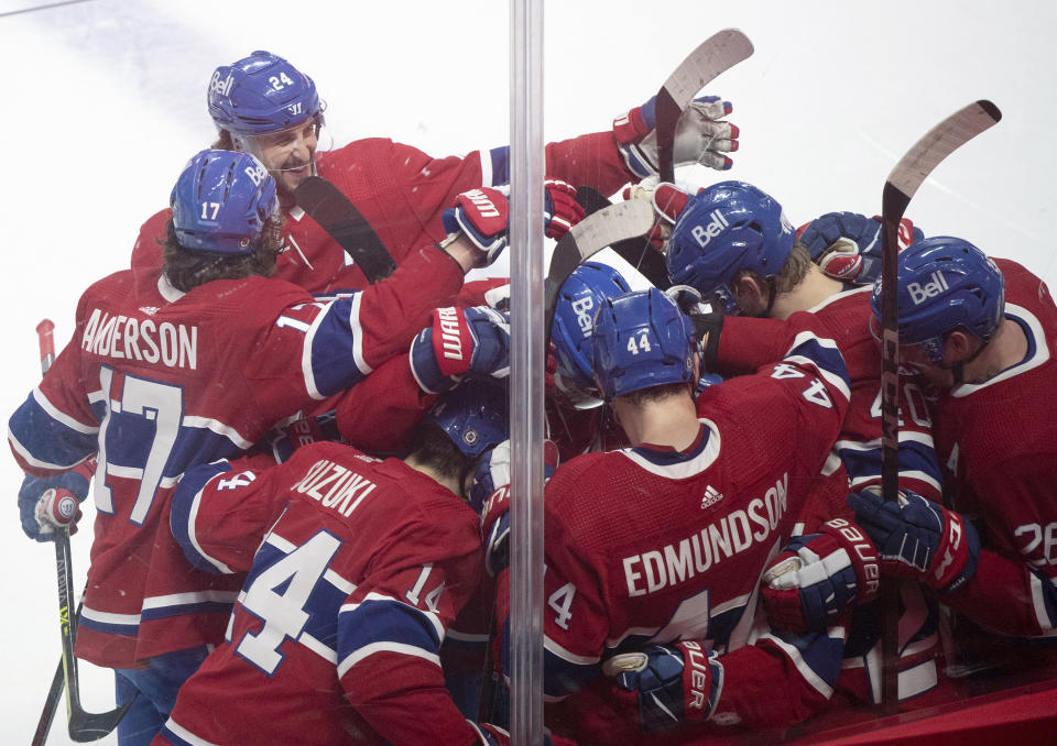 Players from the Montreal Canadiens celebrate Cole Caufield's goal against the Toronto Maple Leafs during overtime NHL hockey game action in Montreal, Monday, May 3, 2021. (Graham Hughes/The Canadian Press via AP)