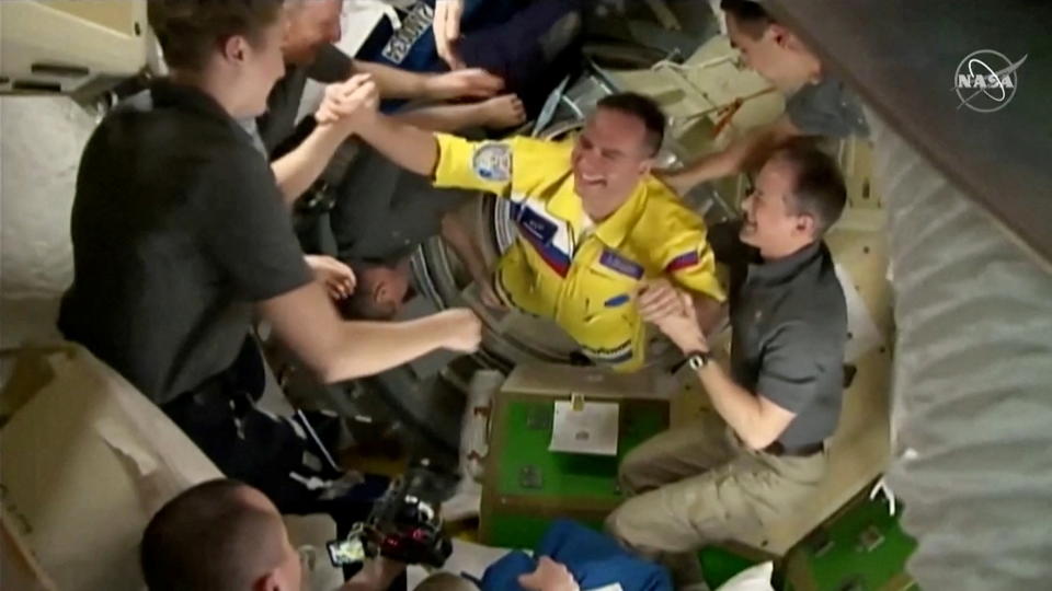 Russian cosmonauts arrive wearing yellow and blue flight suits at the International Space Station after docking their Soyuz capsule March 18, 2022 i a still image from video. Video taken March 18, 2022.  NASA TV/Handout via REUTERS.  THIS IMAGE HAS BEEN SUPPLIED BY A THIRD PARTY.