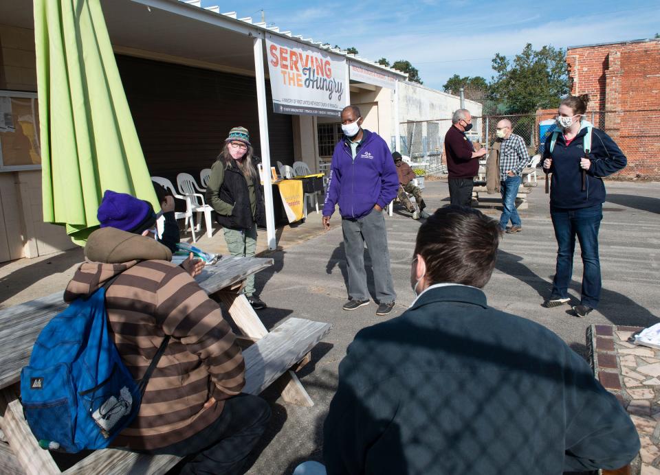 At center, Edward Varnado, with Opening Doors Northwest Florida, and a group of volunteer homeless census takers meet clients at the Serving the Hungry soup kitchen on Monday. Opening Doors is helping to coordinate the annual point-in-time homeless count to assess the homeless population in Escambia and Santa Rosa counties.