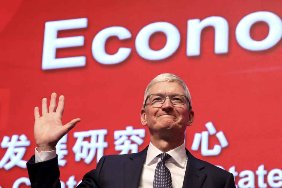 Apple CEO Tim Cook waves as he arrives for the Economic Summit held for the China Development Forum in Beijing, China, Saturday, March 23, 2019. Cook says he's "extremely bullish" about the global economy based on the amount of innovation being carried out, and he's urging China to continue to "open up." (AP Photo/Ng Han Guan)